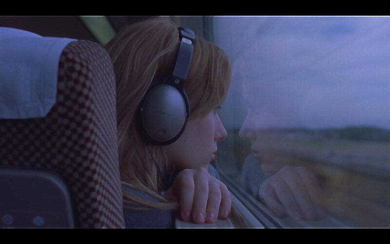 woman on train with headphones