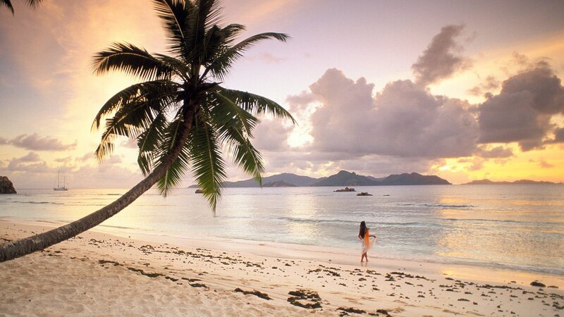 Woman on tropical beach at sunset