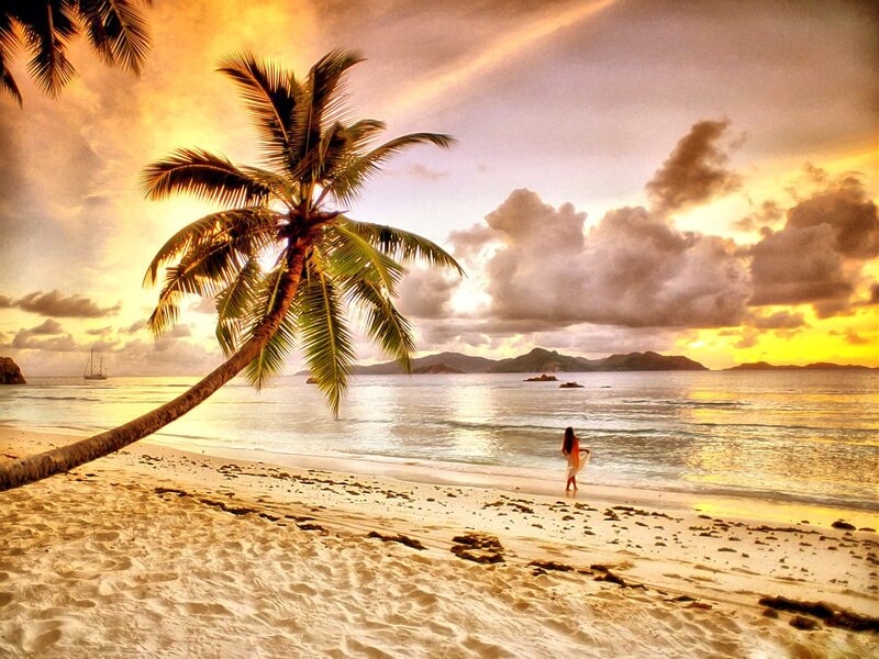 Woman on tropical beach at sunset