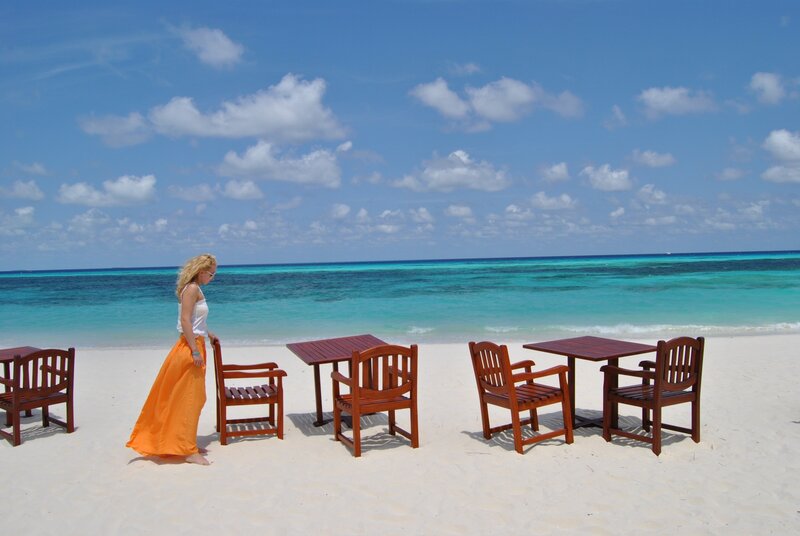 Woman on tropical beach with tables