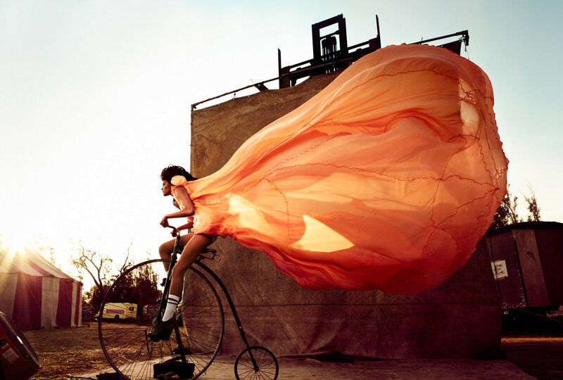 Woman on vintage bicycle with orange fabric