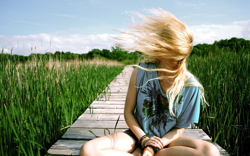 Woman on wooden dock with wind-blown hair
