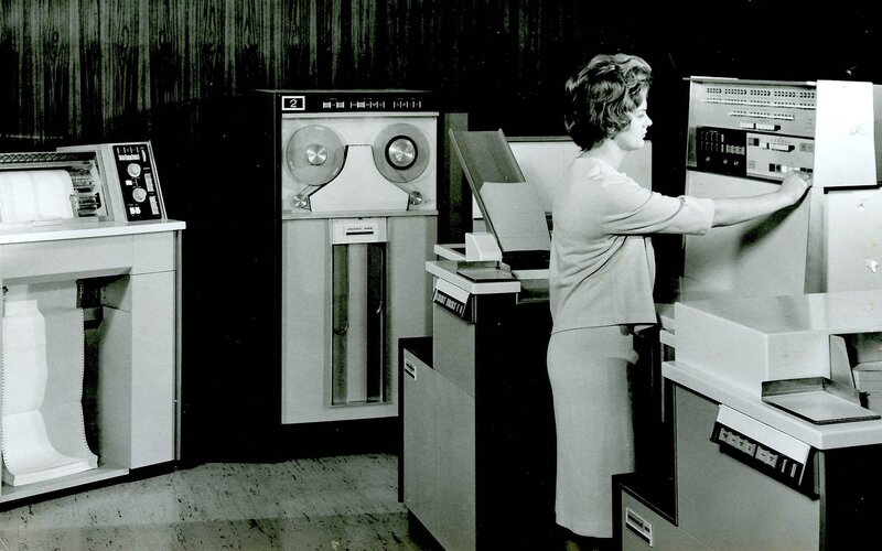 Woman operating vintage computer equipment