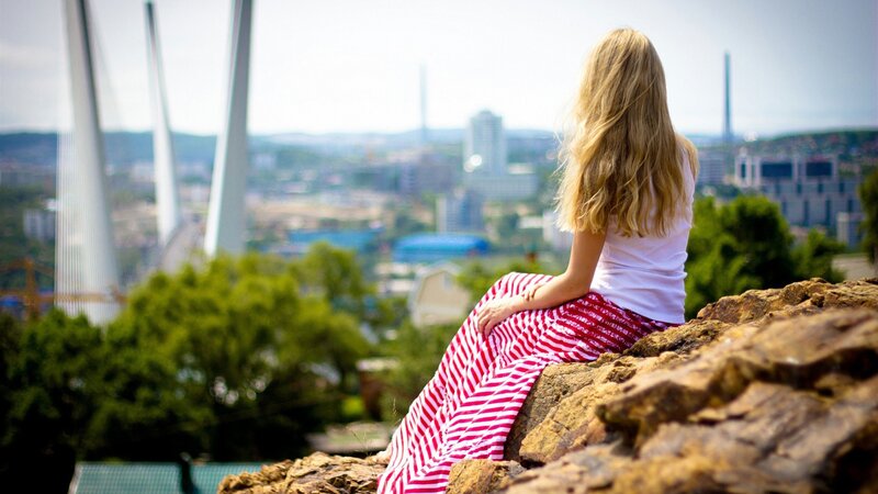 Woman overlooking city from hill