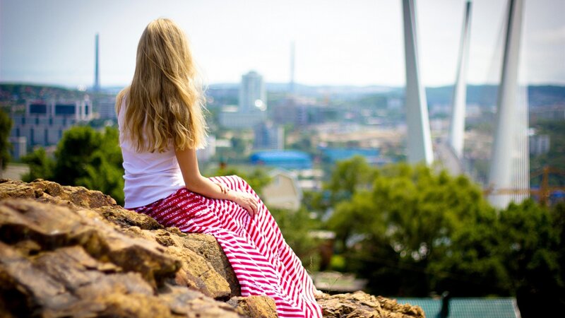 Woman overlooking city from hill
