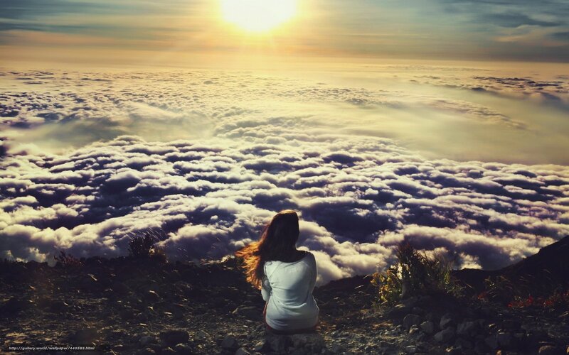 Woman overlooking clouds at sunrise