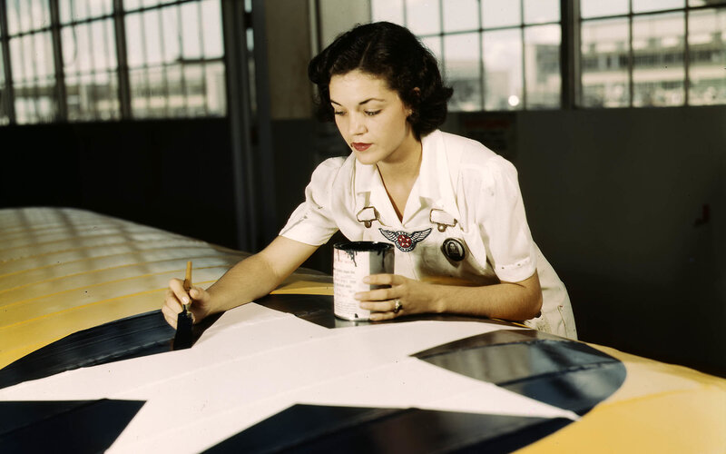 Woman painting aircraft insignia