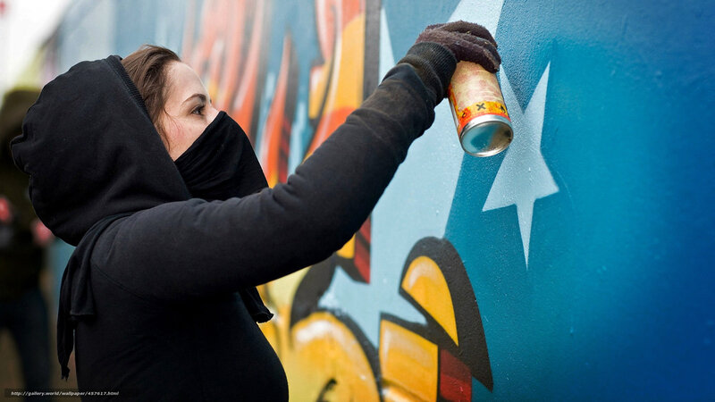 woman painting graffiti on wall