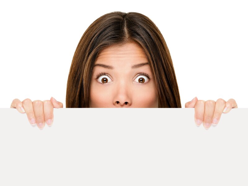 woman peeking behind sign