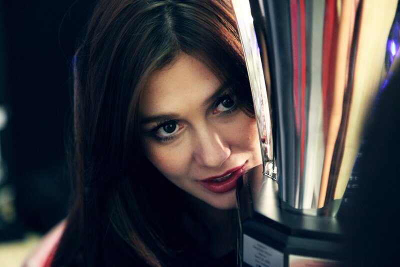 woman peeking behind trophy