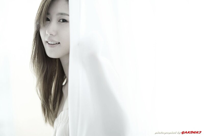 woman peeking from behind a curtain