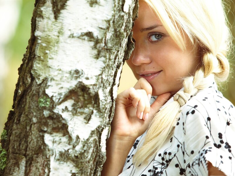 woman peeking from behind a tree