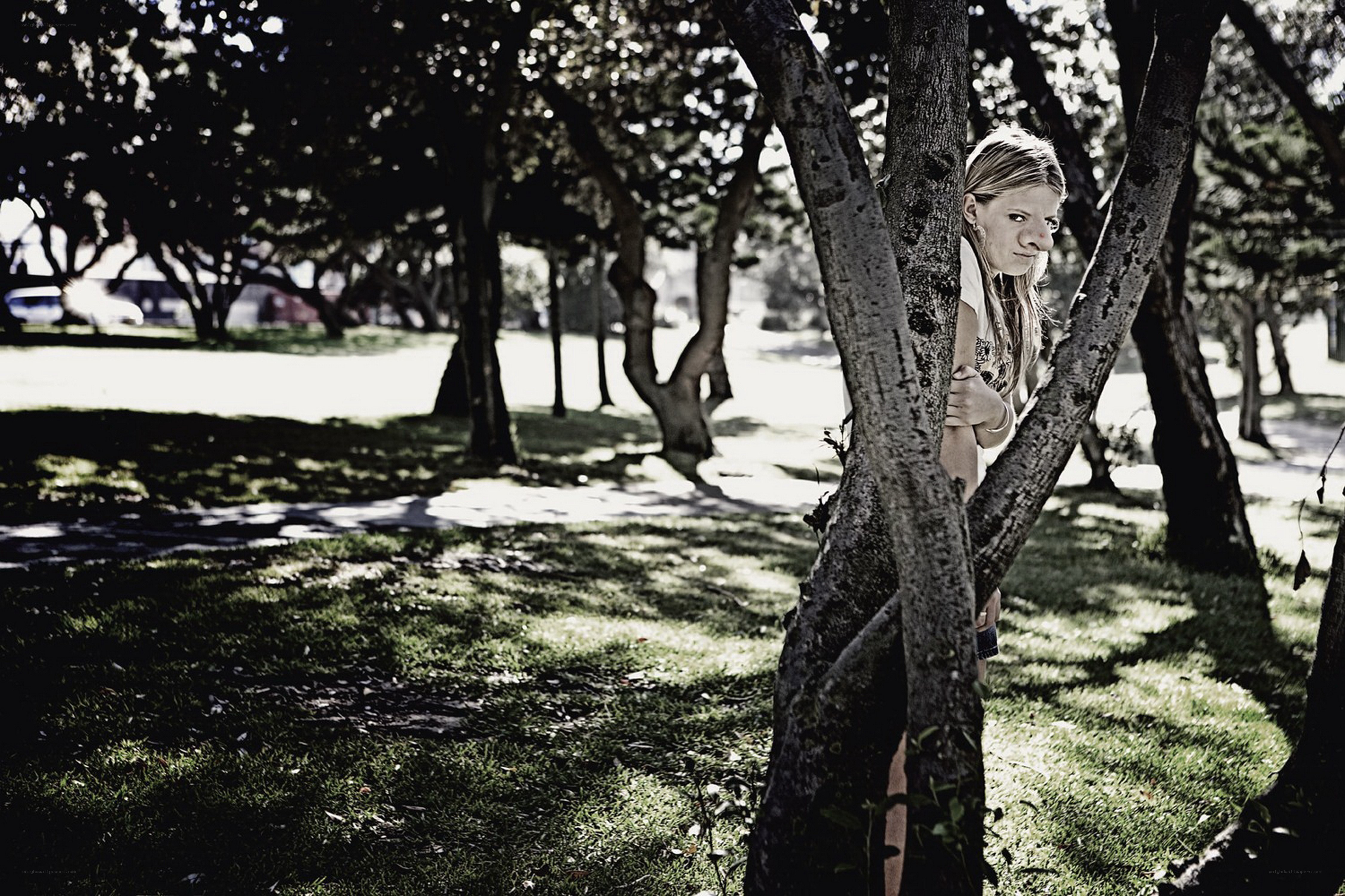 woman peeking from behind a tree