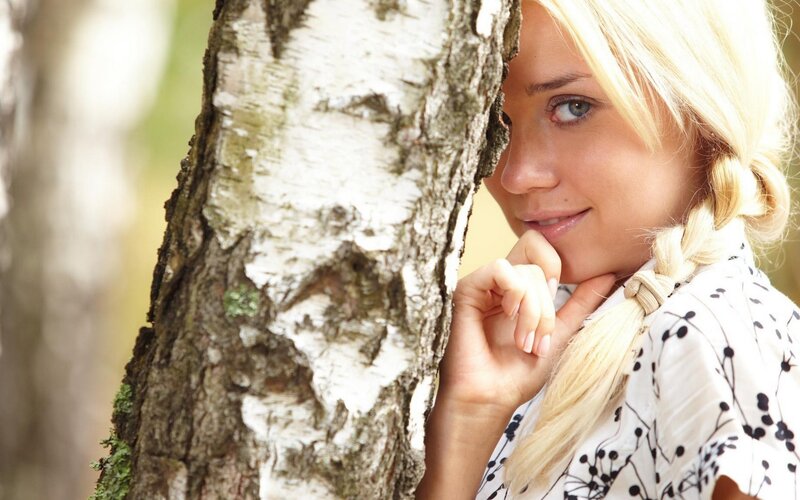 woman peeking from behind a tree
