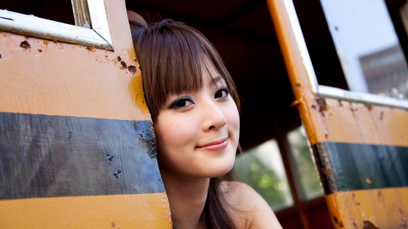 woman peeking from behind a vehicle