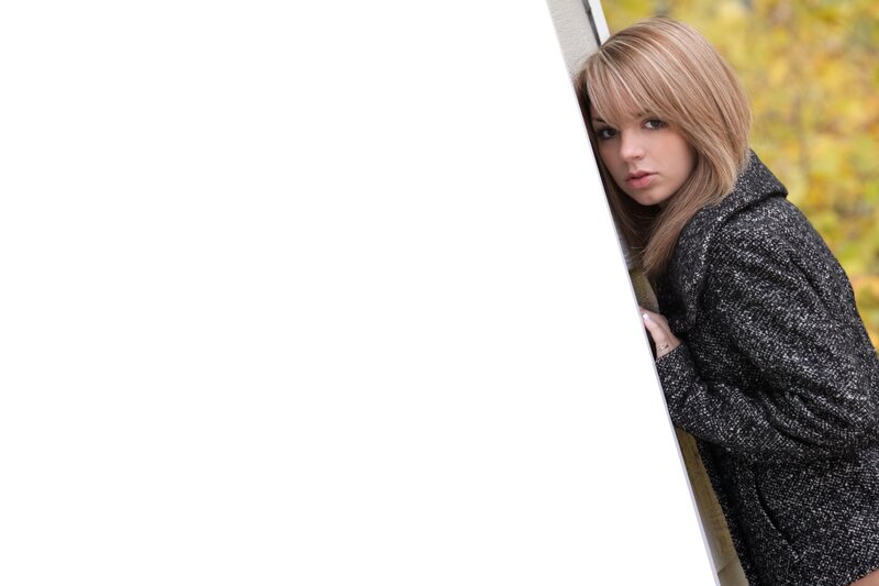 woman peeking from behind a wall