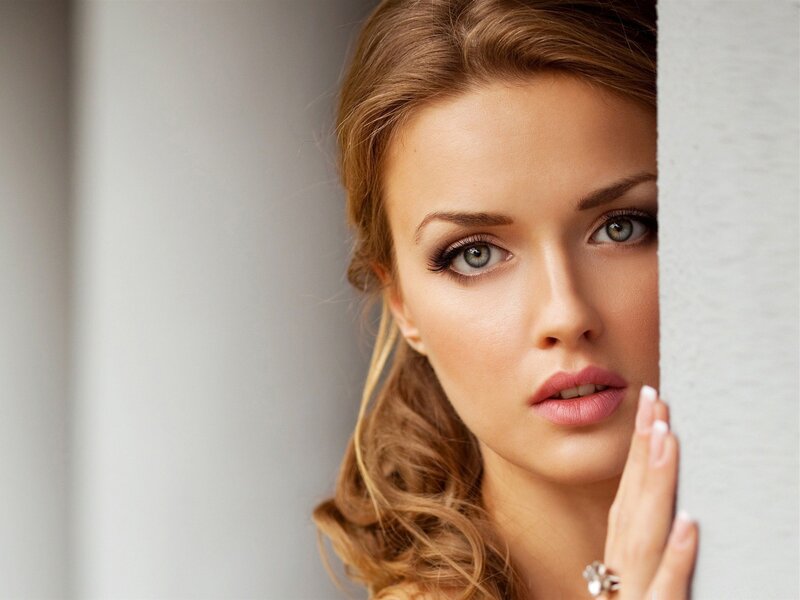 woman peeking from behind a wall