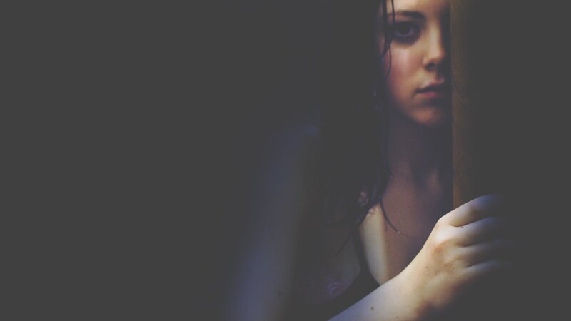 woman peeking from behind a wall