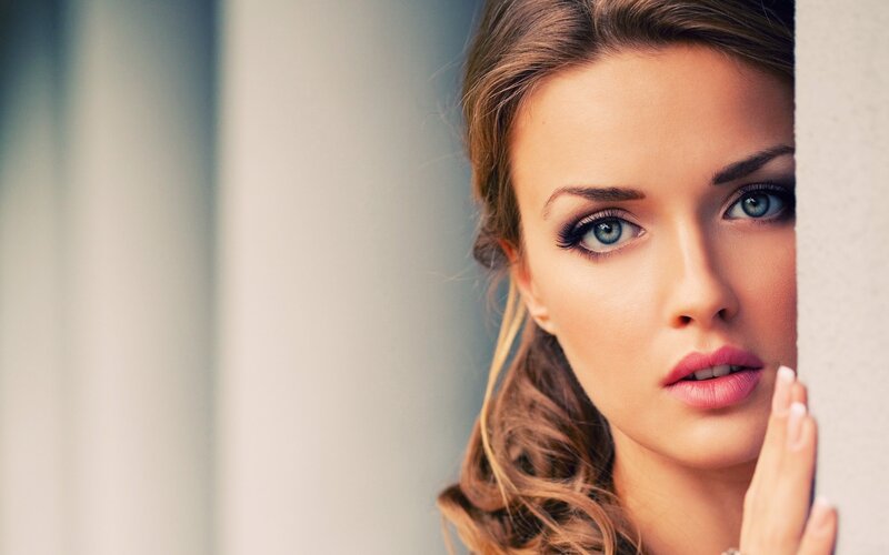 woman peeking from behind a wall