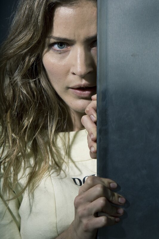 woman peeking from behind a wall