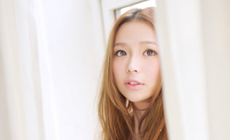 woman peeking from behind curtain