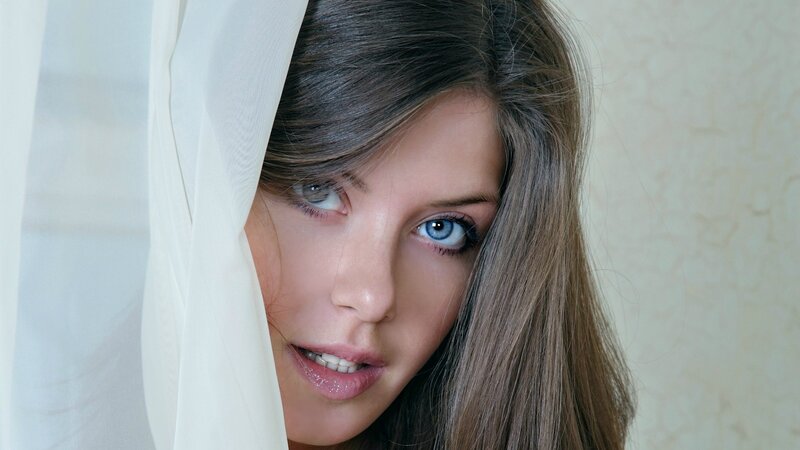woman peeking from behind curtain