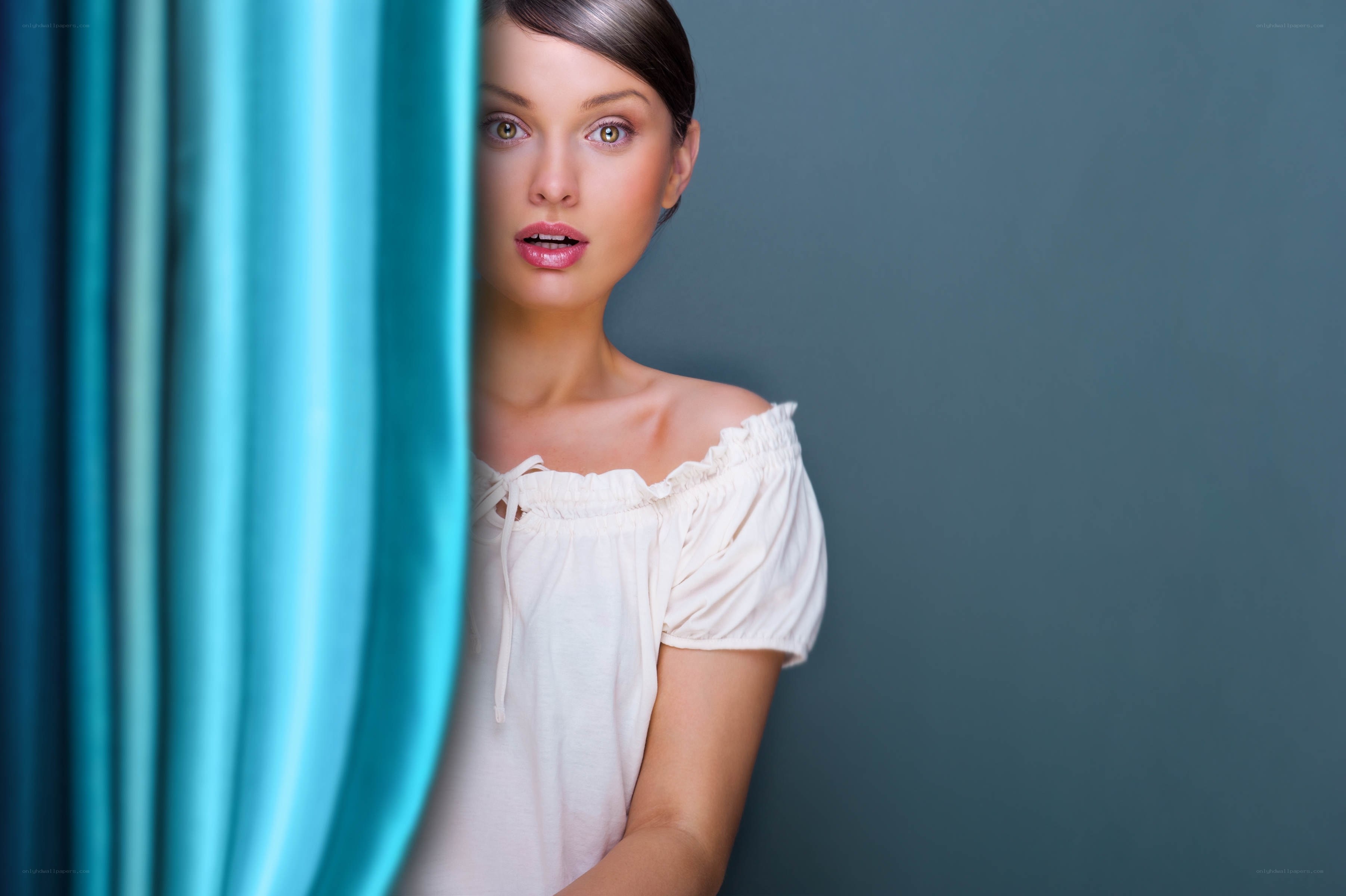 woman peeking from behind curtain