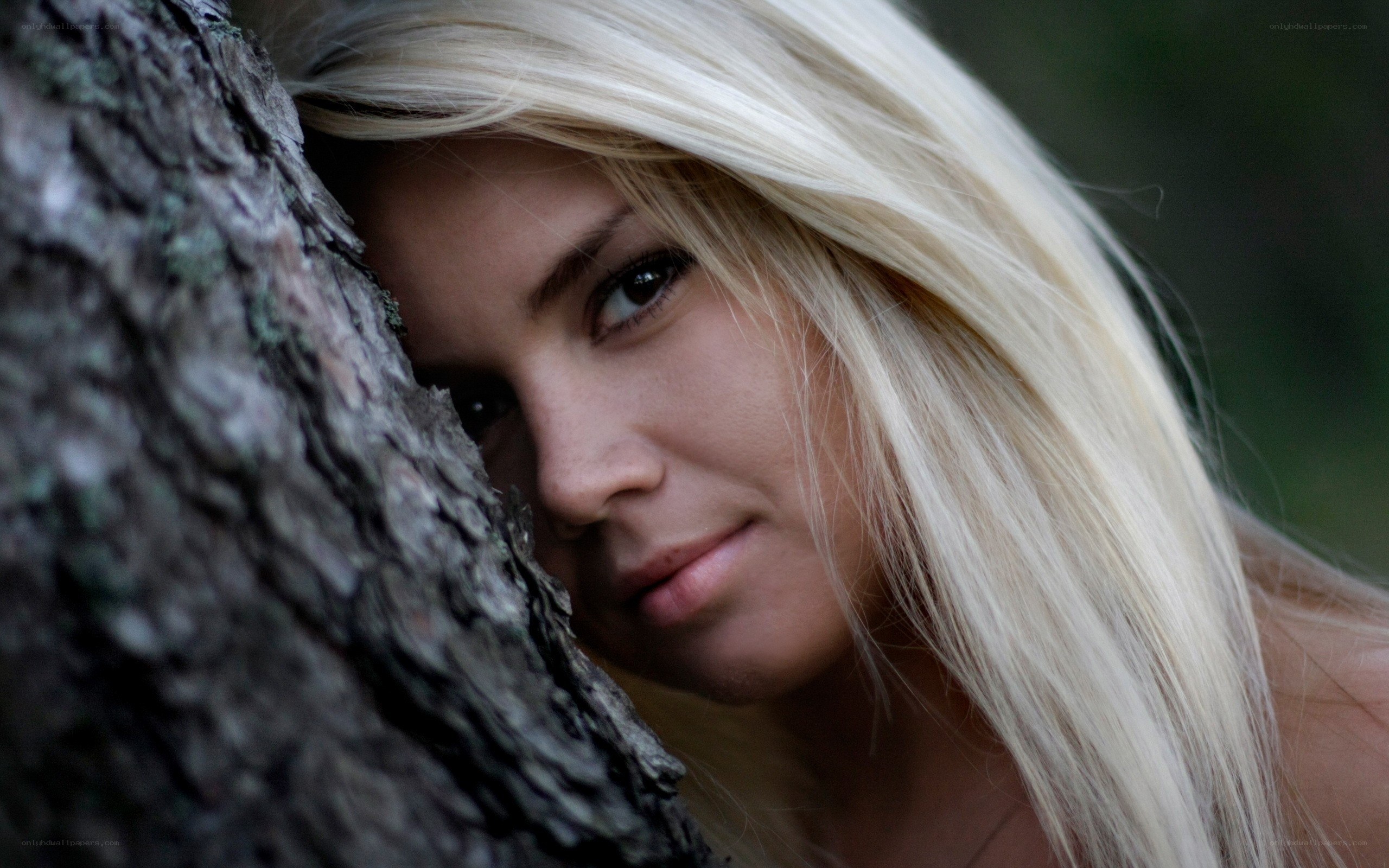 woman peeking from behind tree