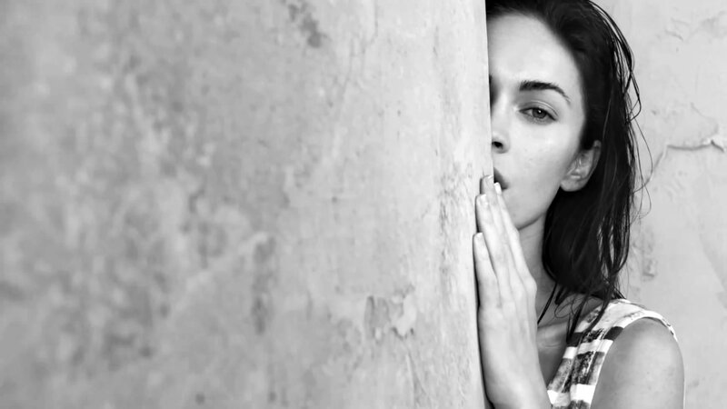 woman peeking from behind wall