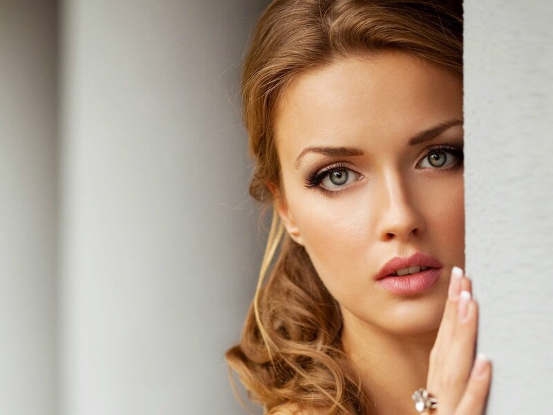 woman peeking from behind wall