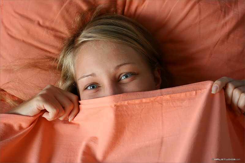 woman peeking from under blanket