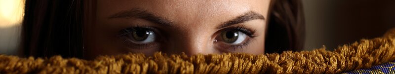 woman peeking over a blanket