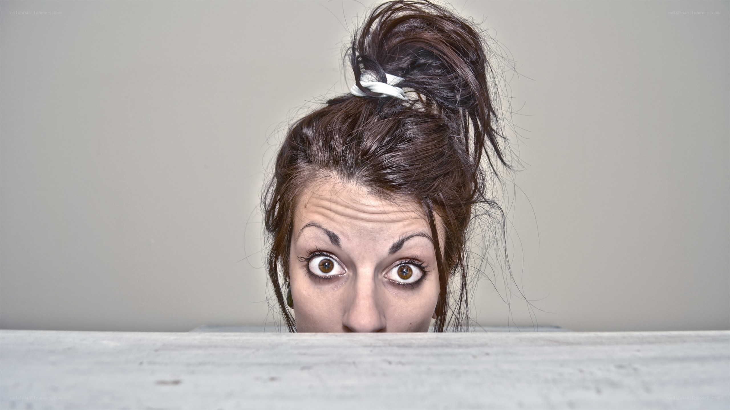woman peeking over edge