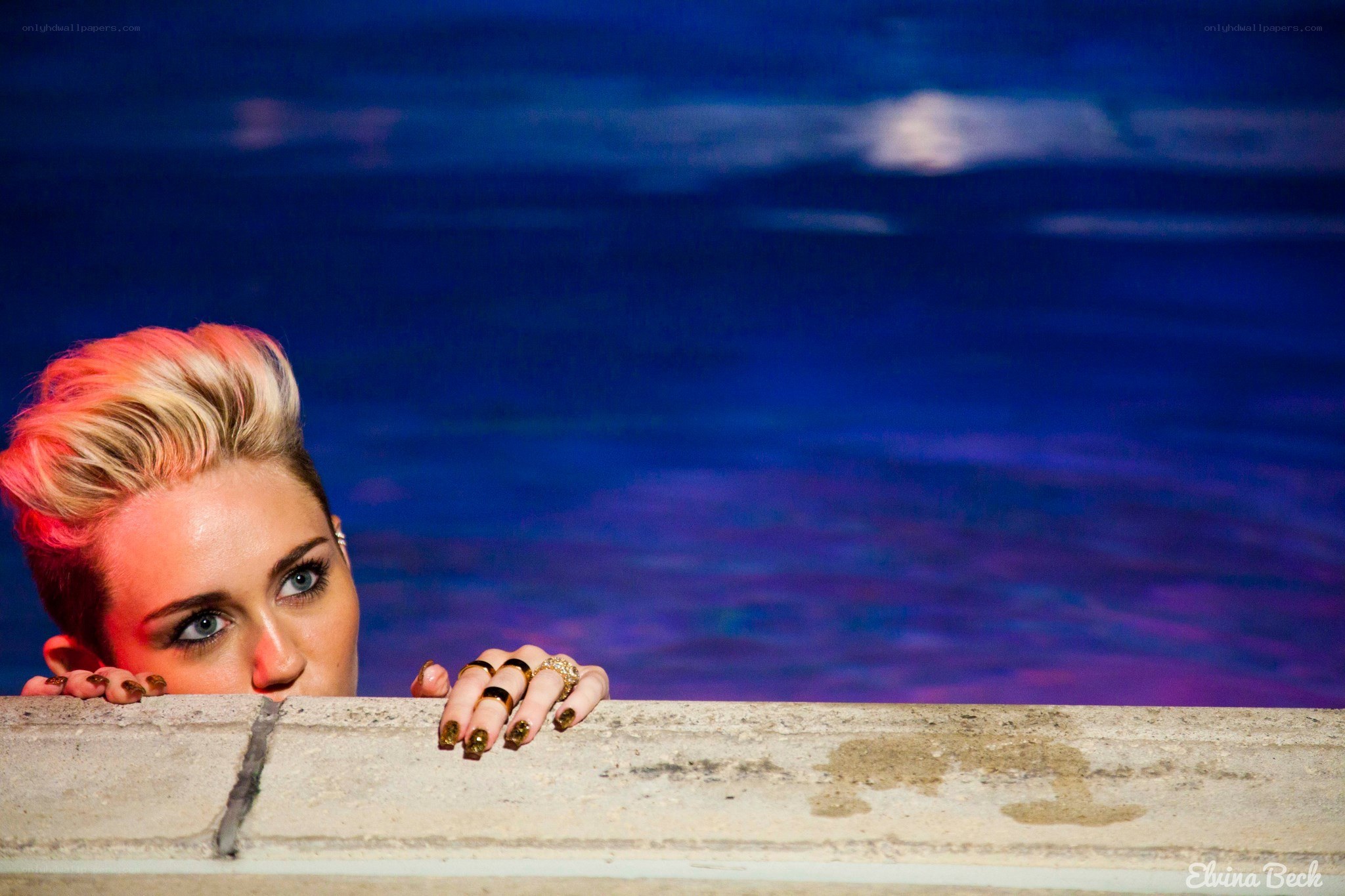 woman peeking over pool edge