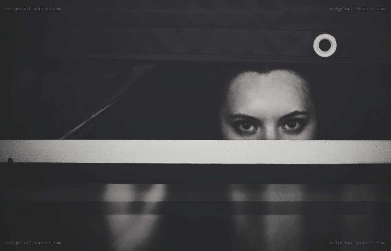 woman peeking through blinds