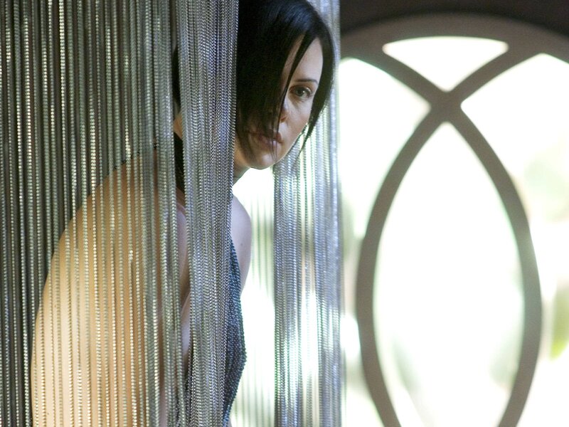 woman peeking through chain curtain