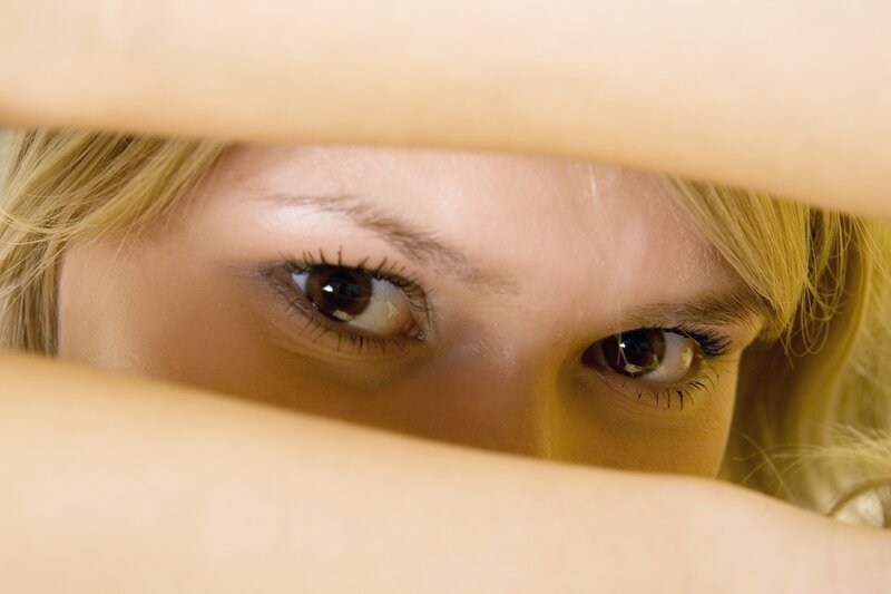 woman peeking through fingers