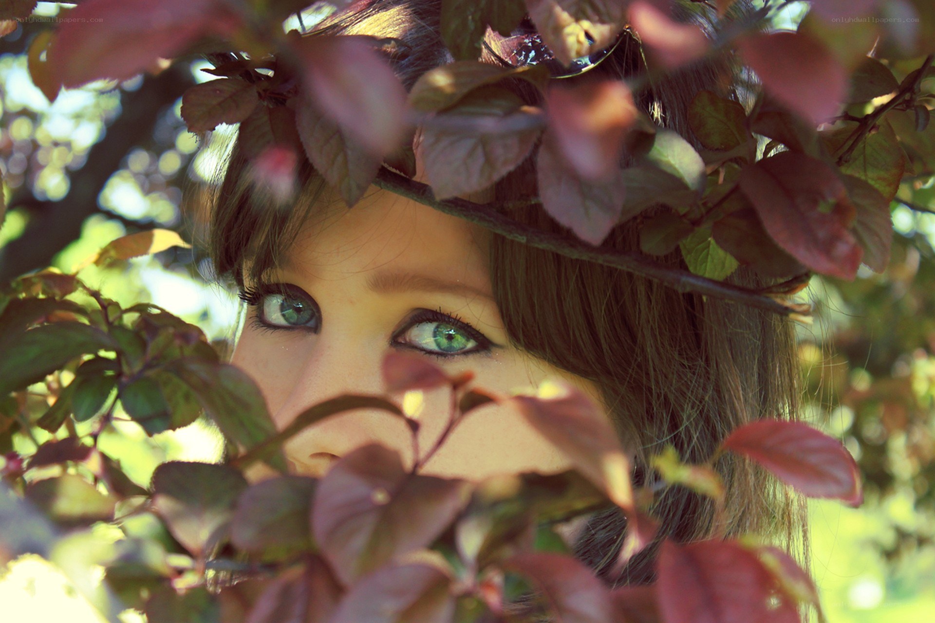 woman peeking through leaves