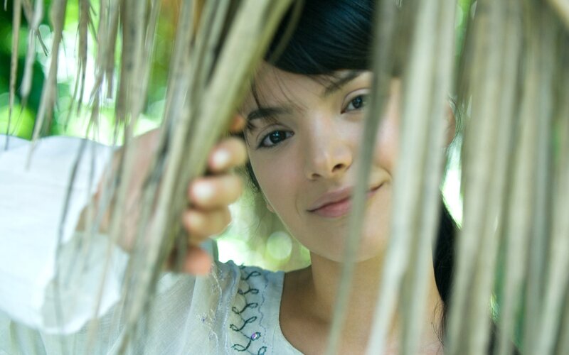 woman peeking through leaves