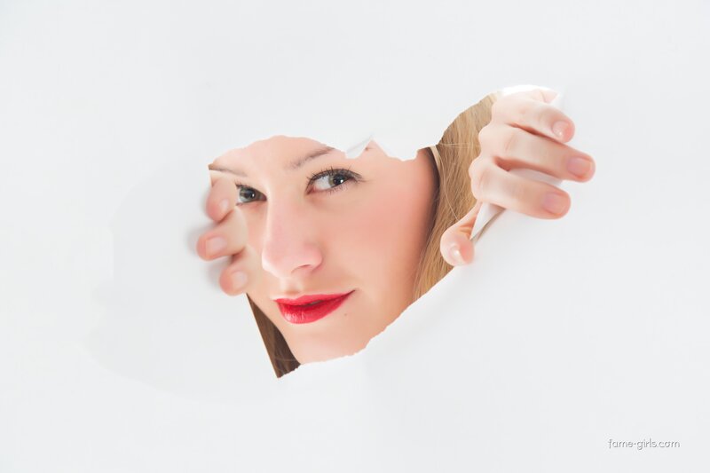woman peeking through paper hole