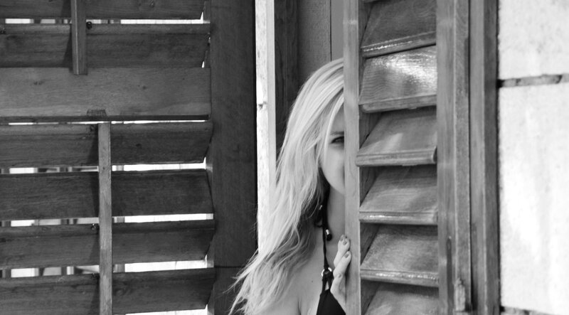 woman peeking through shutters