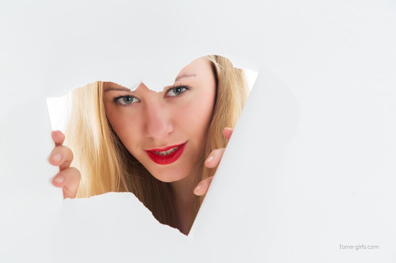 woman peeking through torn paper