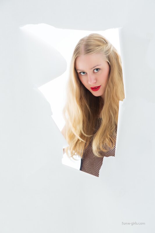 woman peeking through torn paper