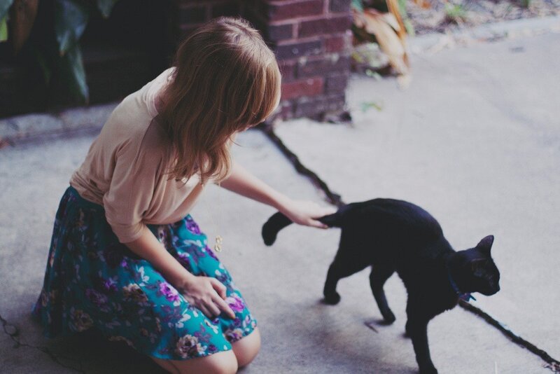 woman petting a black cat