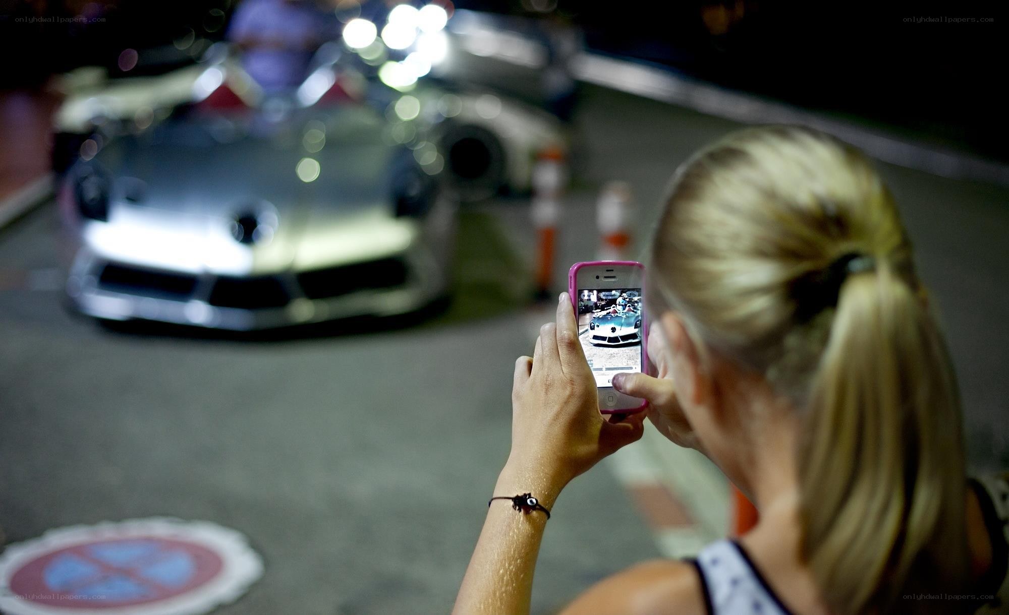 Woman photographing a car