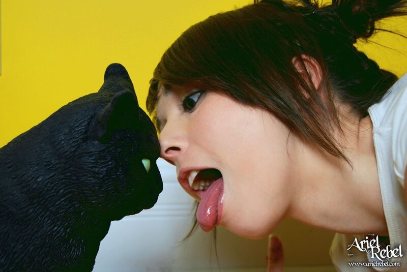 woman playfully interacting with black cat