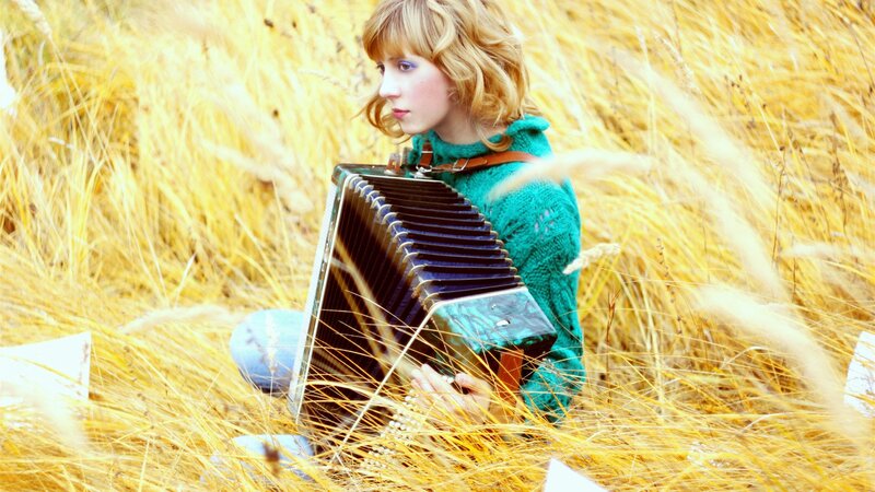 Woman playing accordion in a field