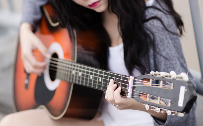Woman Playing Acoustic Guitar — Brown