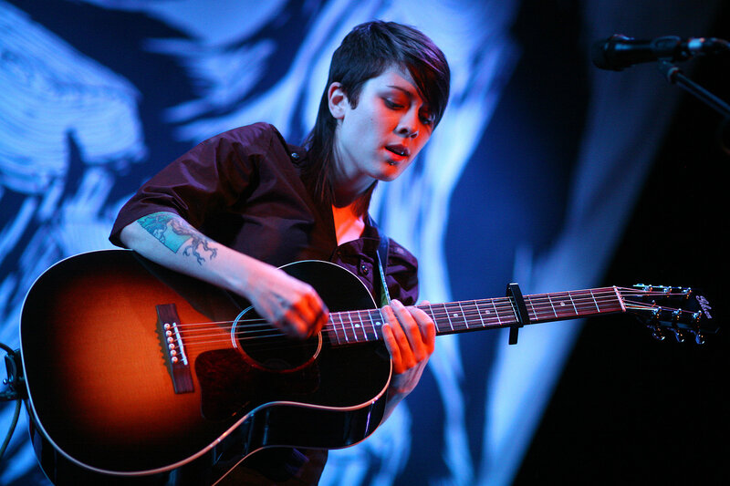 woman playing acoustic guitar on stage