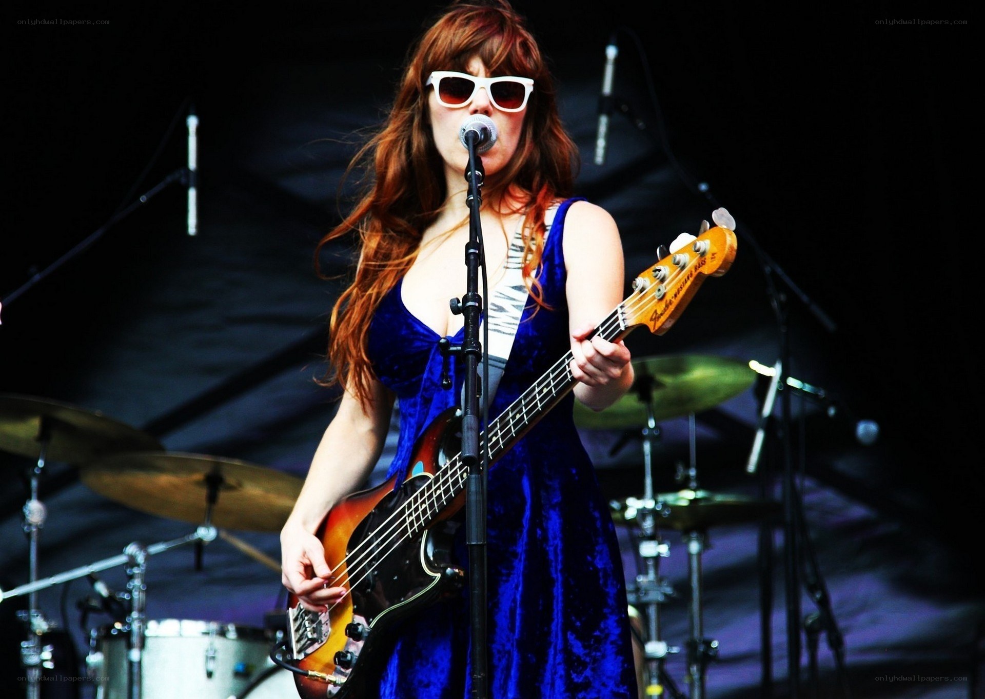 Woman playing bass guitar on stage